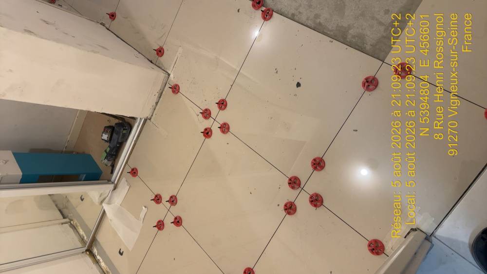 pose d'un carrelage grand format dans le couloir d'un appartement en rénovation en Essonne par HOME Éditions.