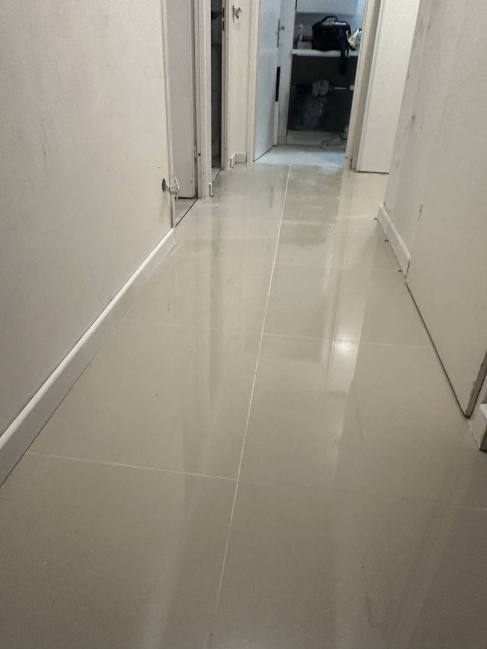 Carrelage posé dans le couloir de l'appartement après préparation et mise à niveau du support.